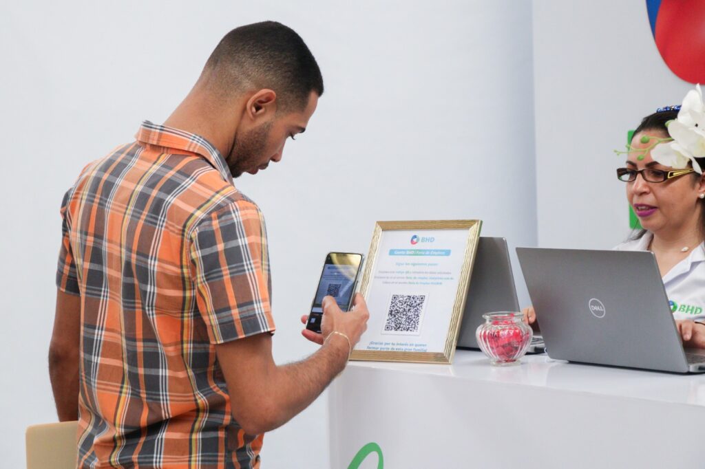 Hombre escanea código QR en feria de empleo.