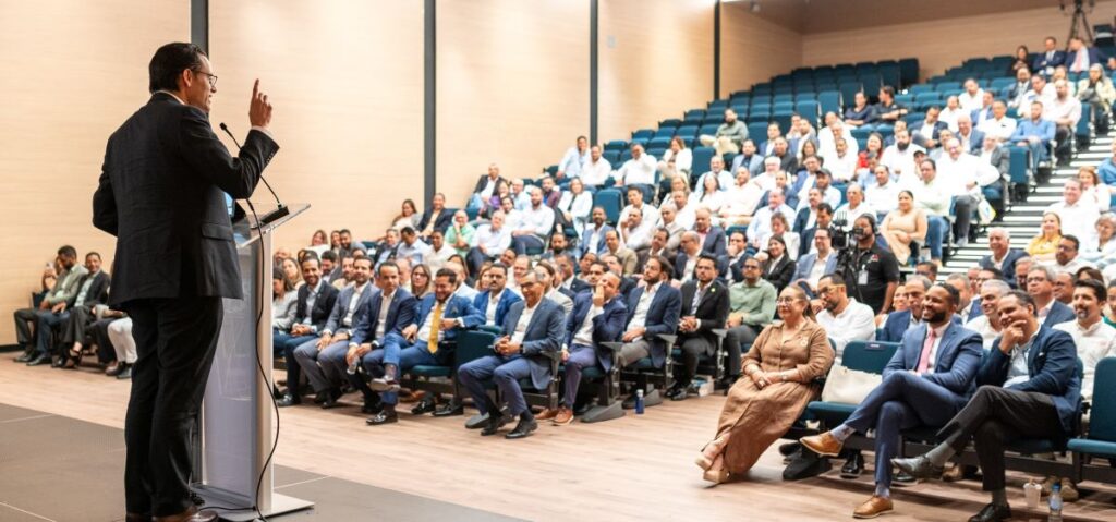 Conferencia ante público numeroso en auditorio moderno