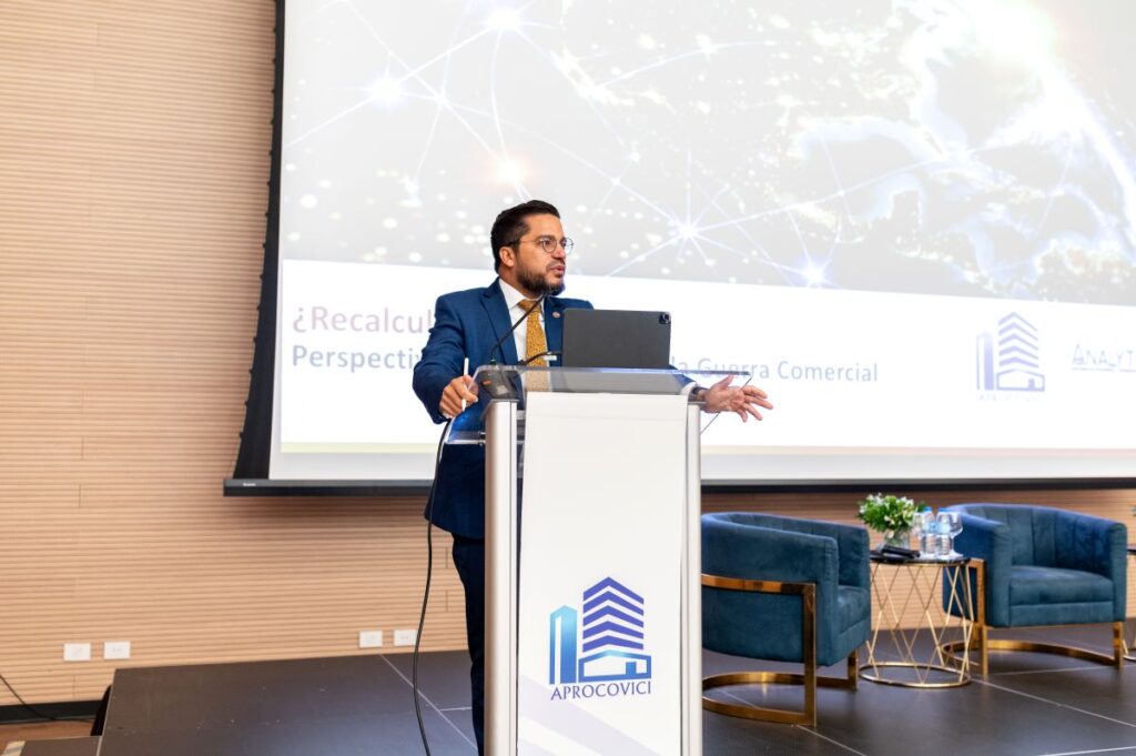 Hombre hablando en conferencia sobre guerra comercial.