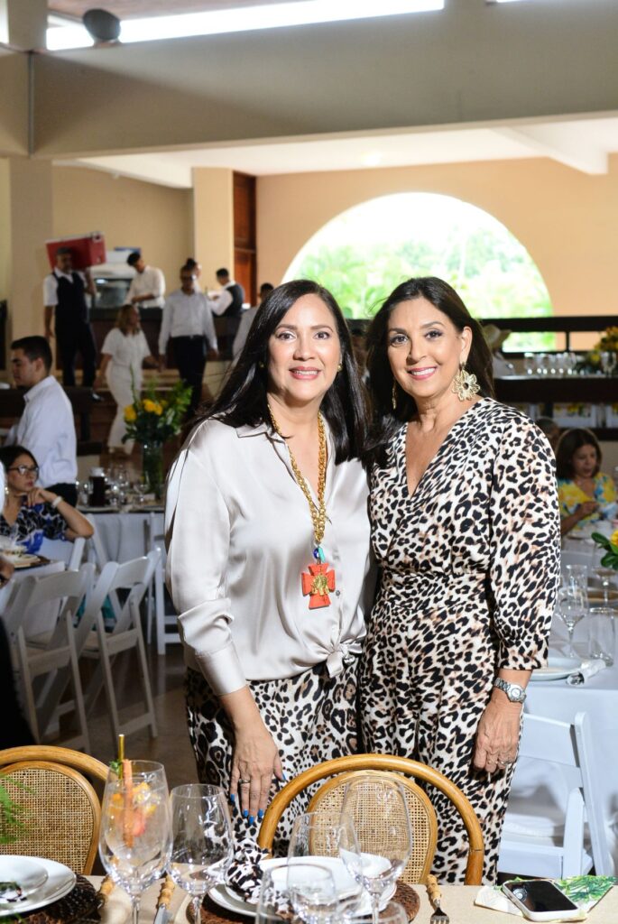 Dos mujeres en evento con vestimenta de leopardo.