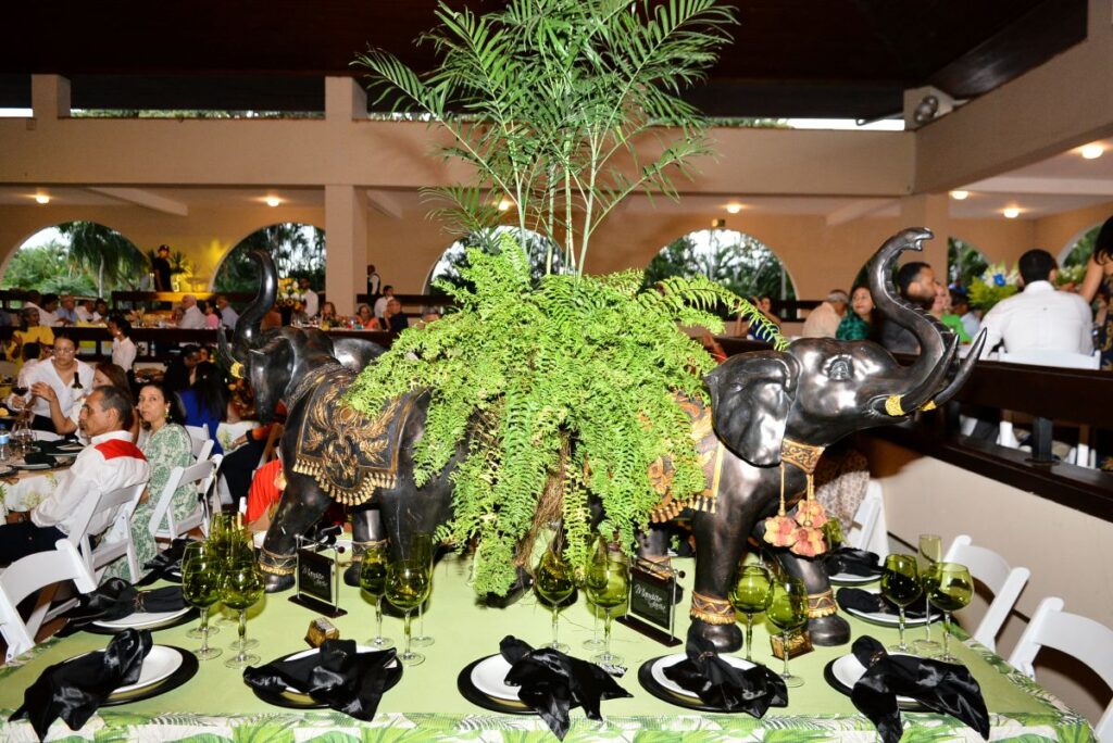 Mesa decorada con elefantes y plantas en evento.
