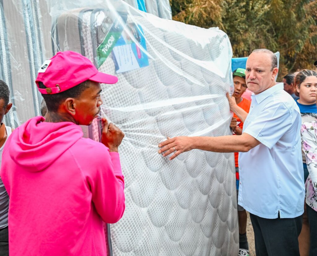 Personas trasladan colchones en un evento comunitario