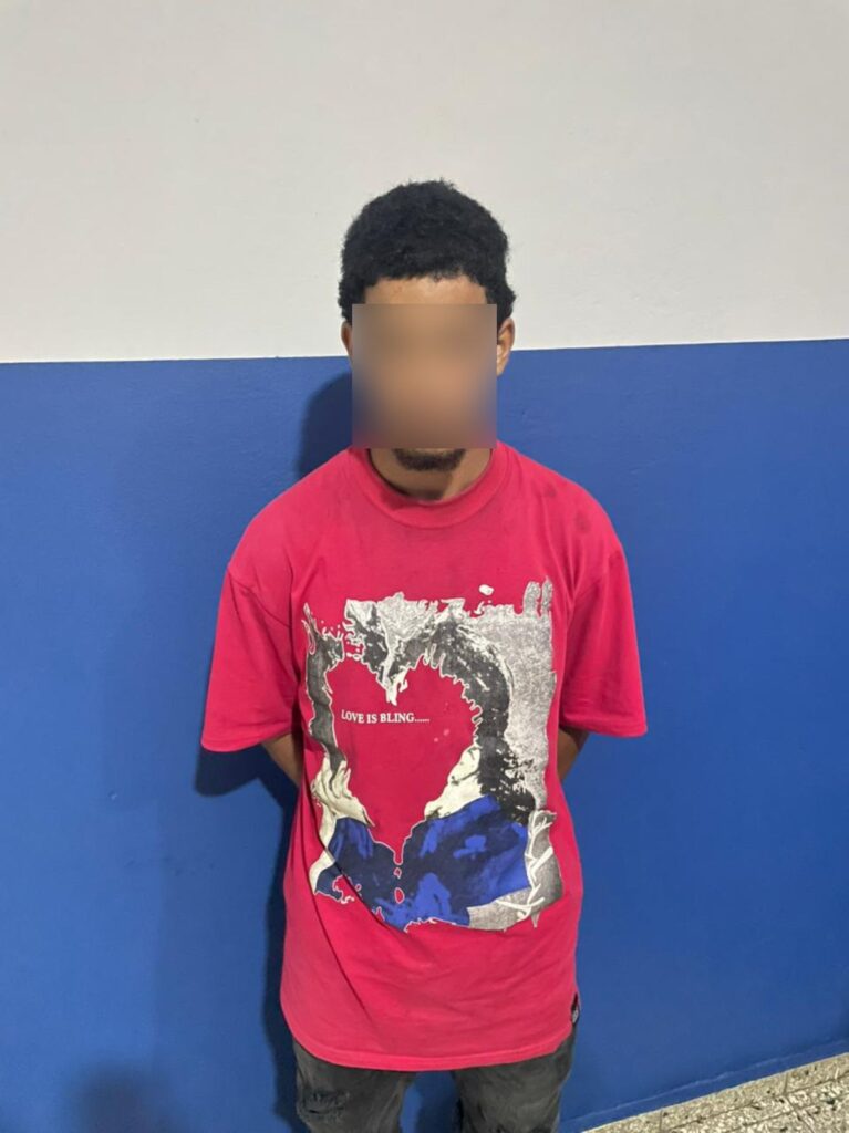 Persona con camiseta roja frente a pared azul