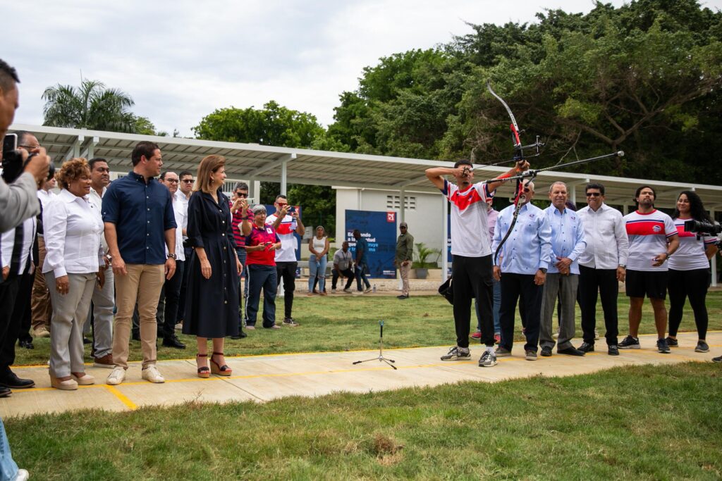 Arquero apunta mientras espectadores observan en evento al aire libre.