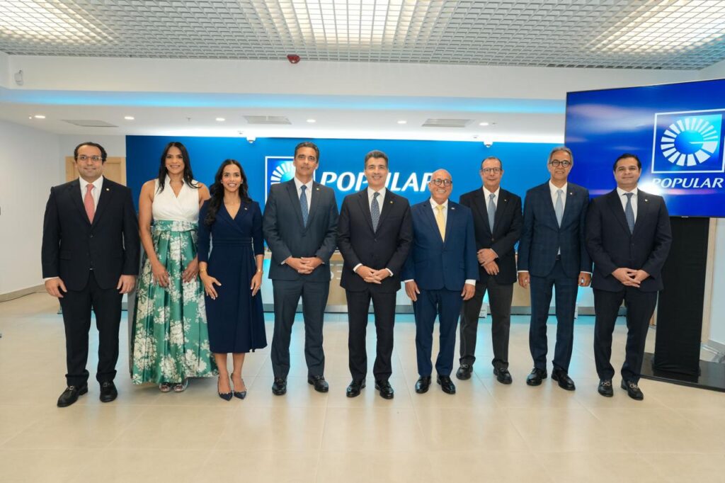 Grupo de personas frente a logo de Popular.