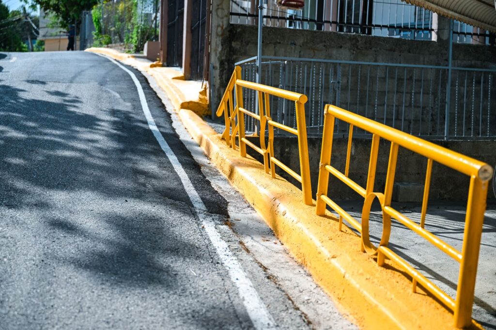 Calle con barandilla amarilla y acera elevada