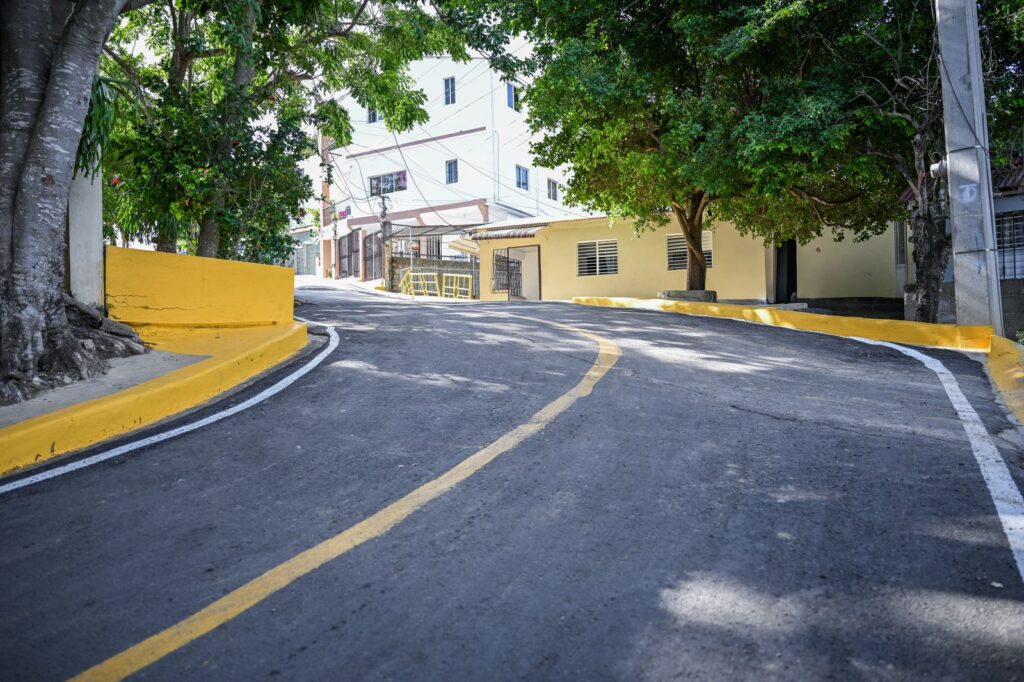 Calle empinada con árboles y edificios cercanos.