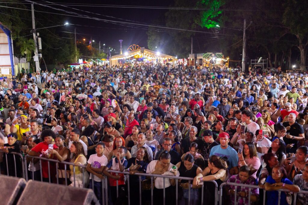 Multitud disfrutando de una feria nocturna colorida.