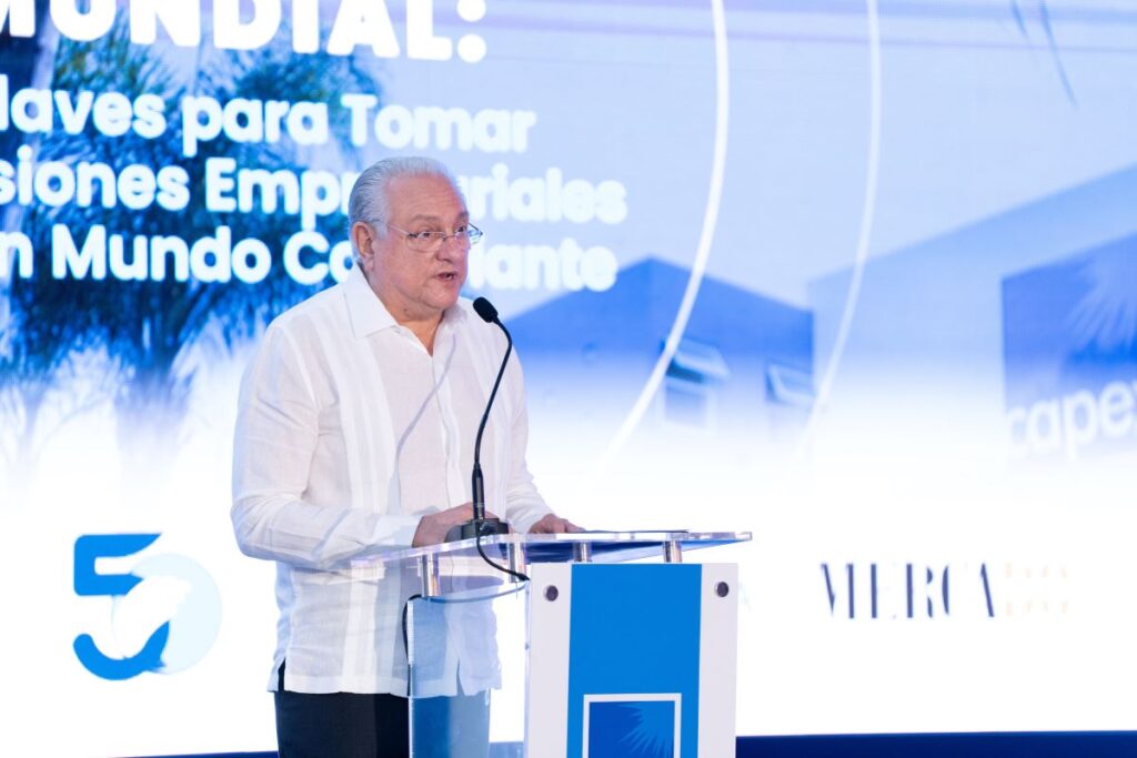 Hombre hablando en conferencia empresarial sobre decisiones globales.