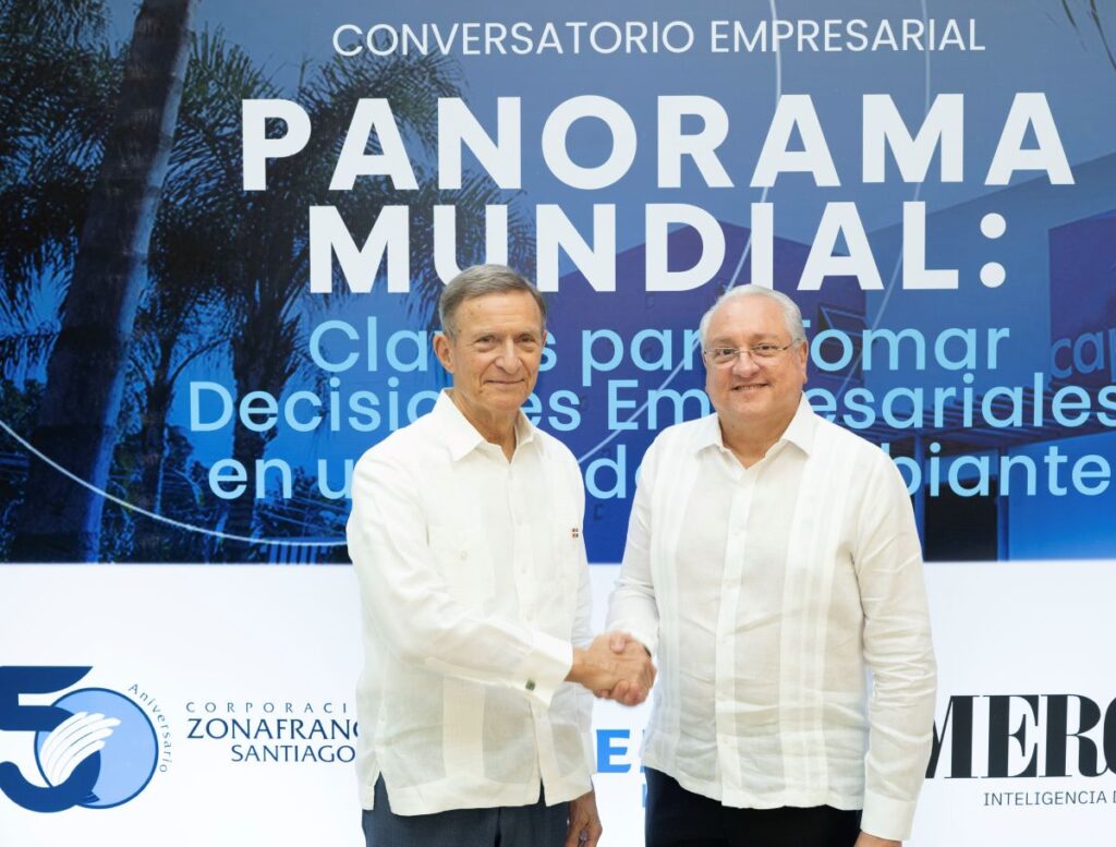 Dos hombres estrechan manos en un evento empresarial.