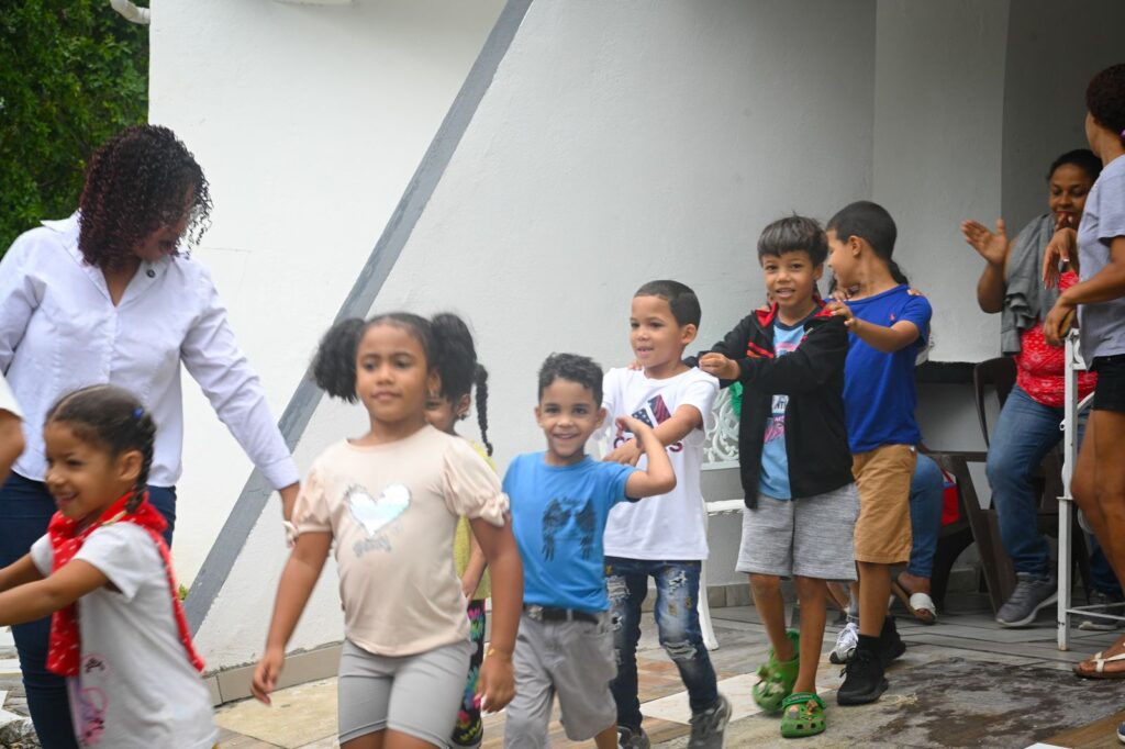 Niños jugando en fila alegremente al aire libre.