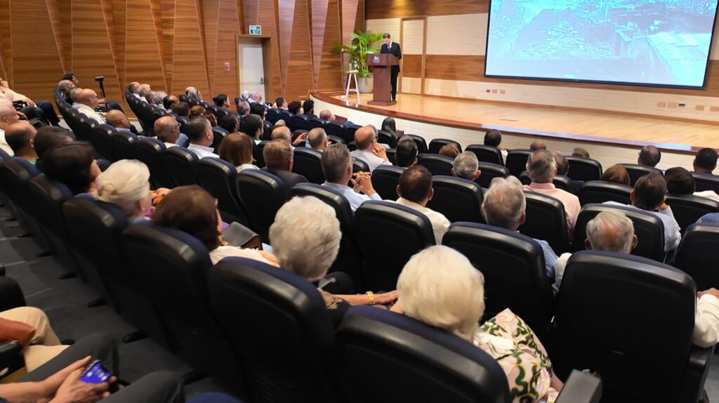 Conferencia en auditorio con público atento y ponente
