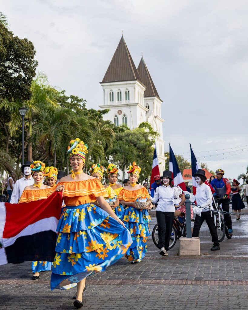 Desfile de baile tradicional con trajes coloridos.