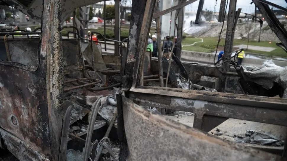 Interior de autobús quemado en área urbana.