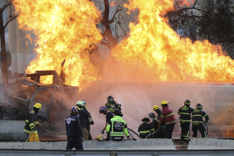 Bomberos extinguen incendio de vehículo en carretera.