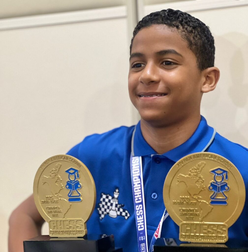 Niño con trofeo de torneo de ajedrez.