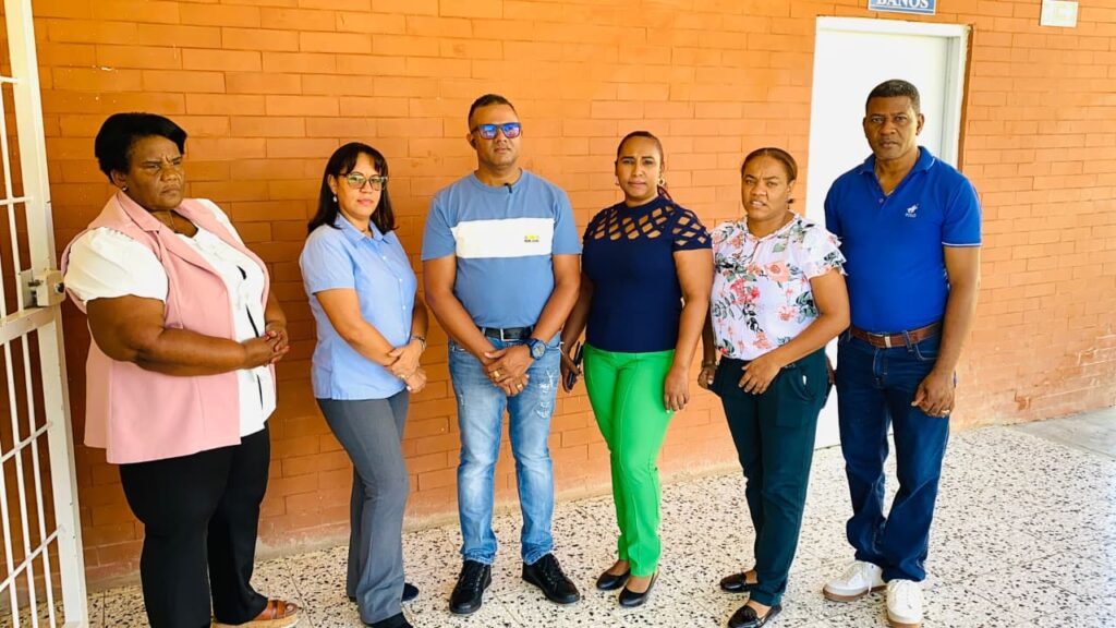 Grupo de personas posando frente a pared.