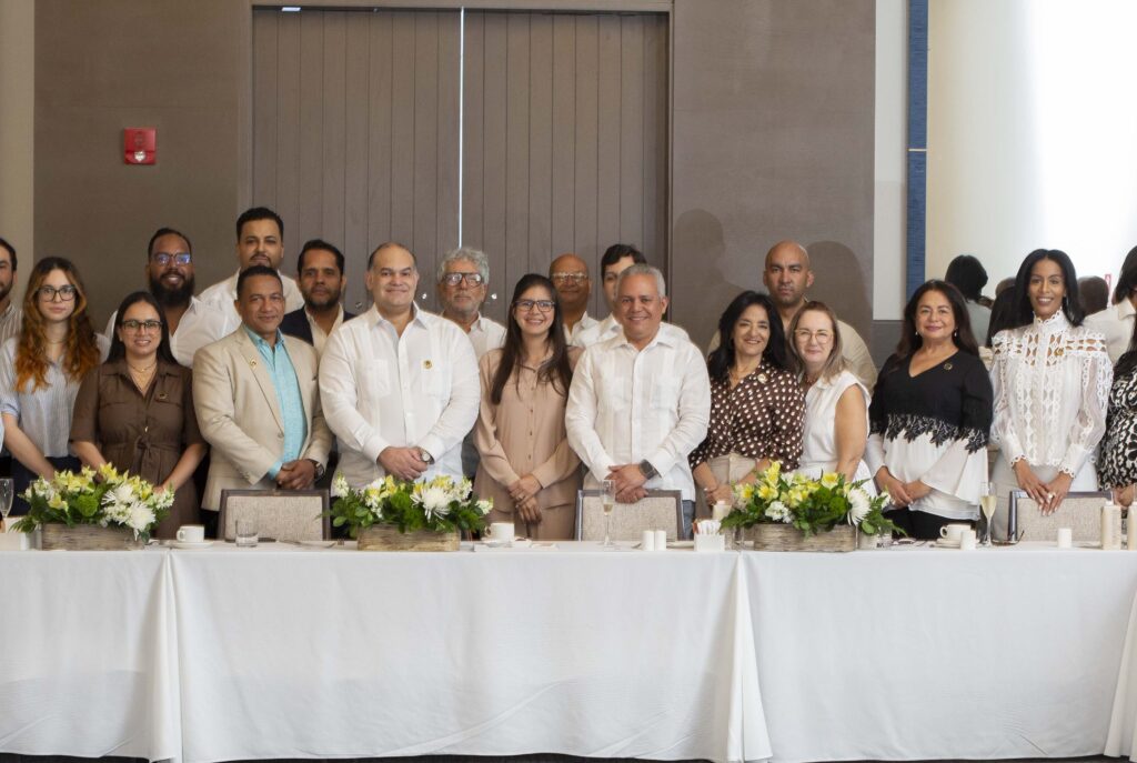Personas posando en grupo junto a una mesa.