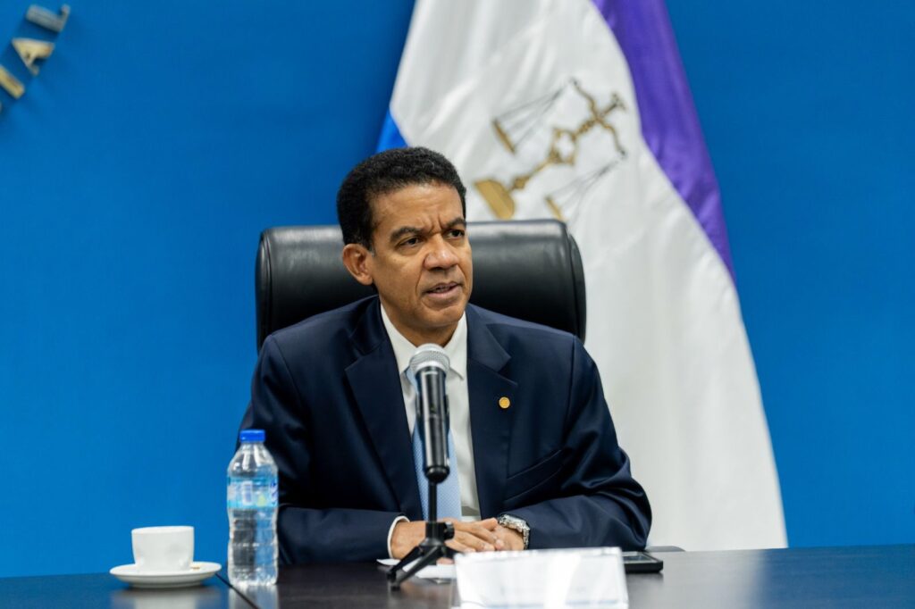 Hombre hablando en conferencia de prensa con micrófono.