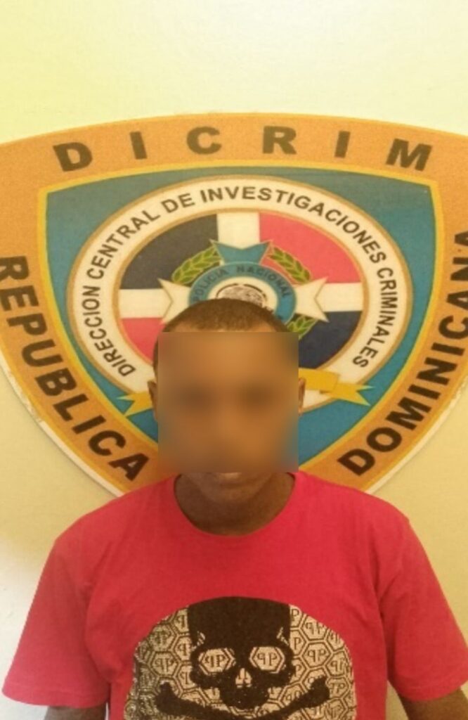 Persona en camiseta roja frente a logo DICRIM.