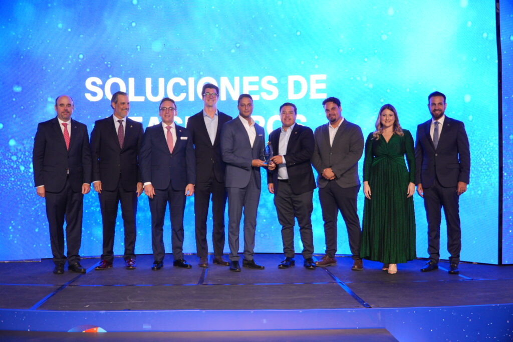 Grupo de personas recibiendo un premio en ceremonia.