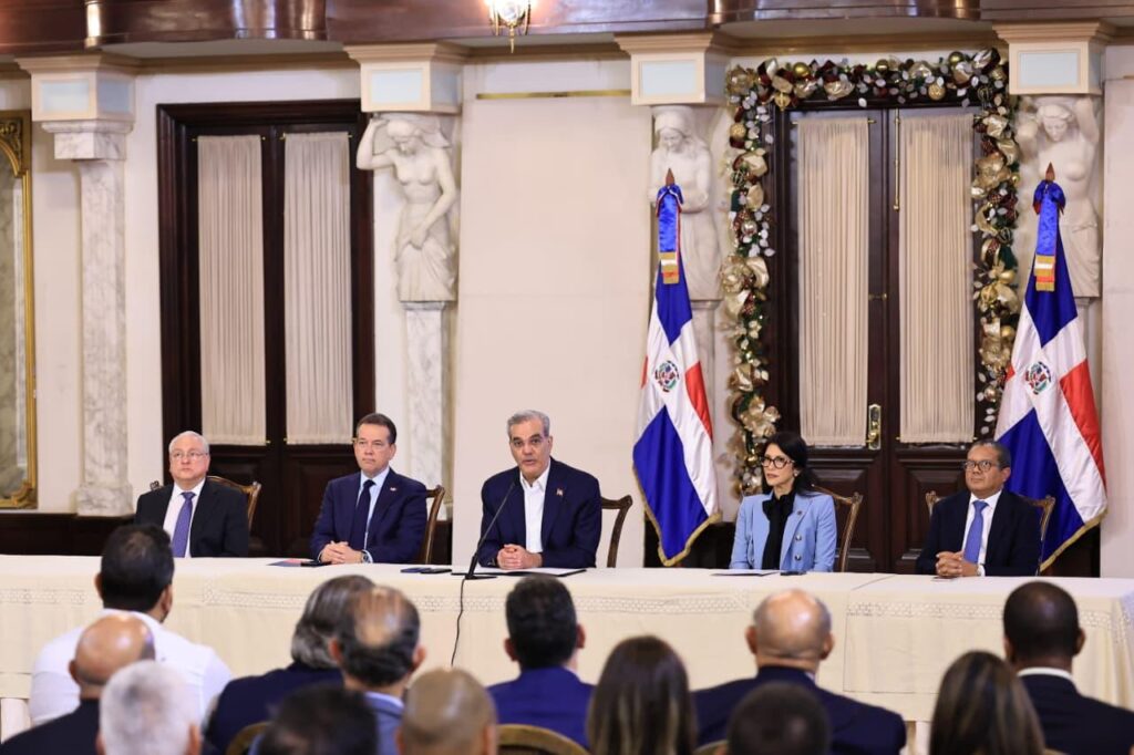 Reunión oficial en palacio con banderas dominicanas.