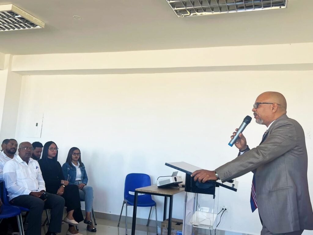 Hombre en traje dando conferencia a grupo pequeño.