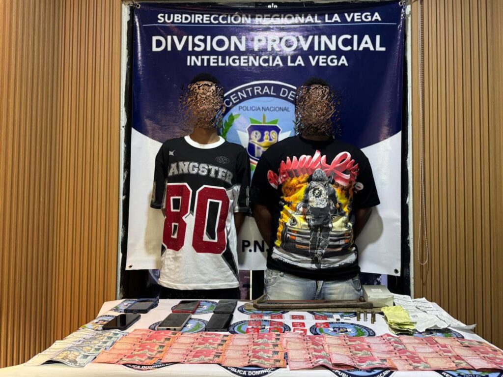 Personas arrestadas por policía con evidencia en table.