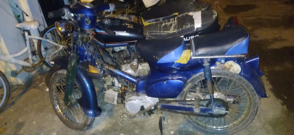Ciclomotor azul antiguo en la calle por la noche.