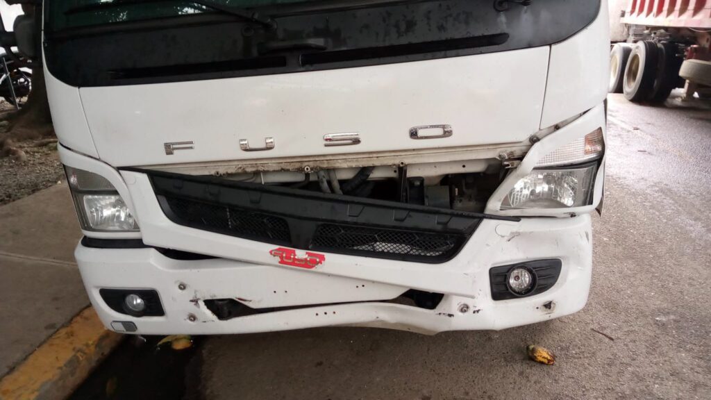 Camión Fuso con daños en el parachoques delantero.