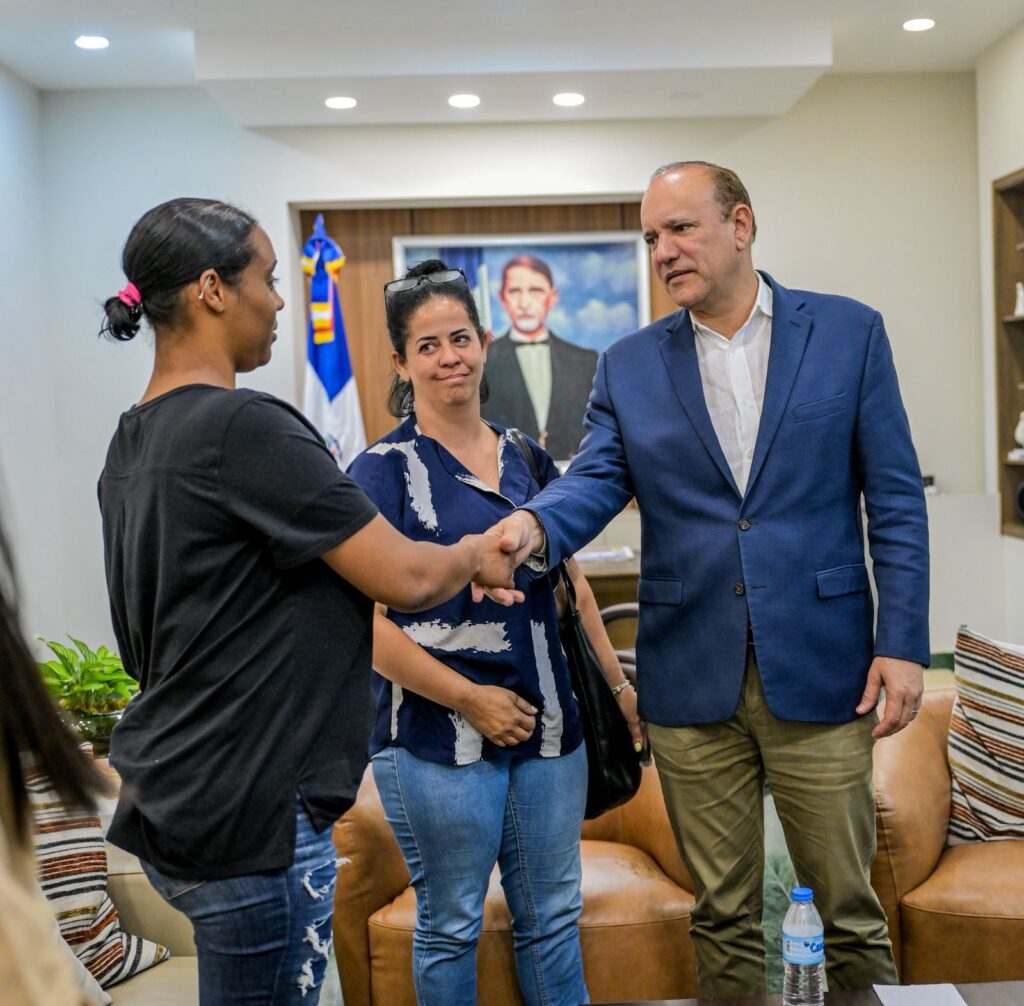 Personas saludándose en reunión oficial.