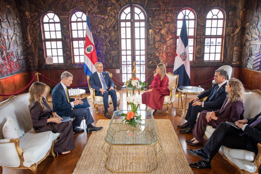 Reunión diplomática en una sala elegante.