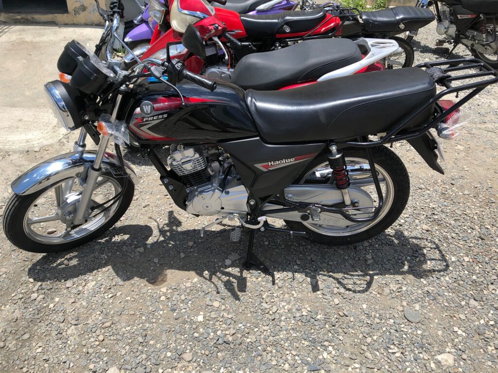 Moto negra y roja aparcada en el exterior.