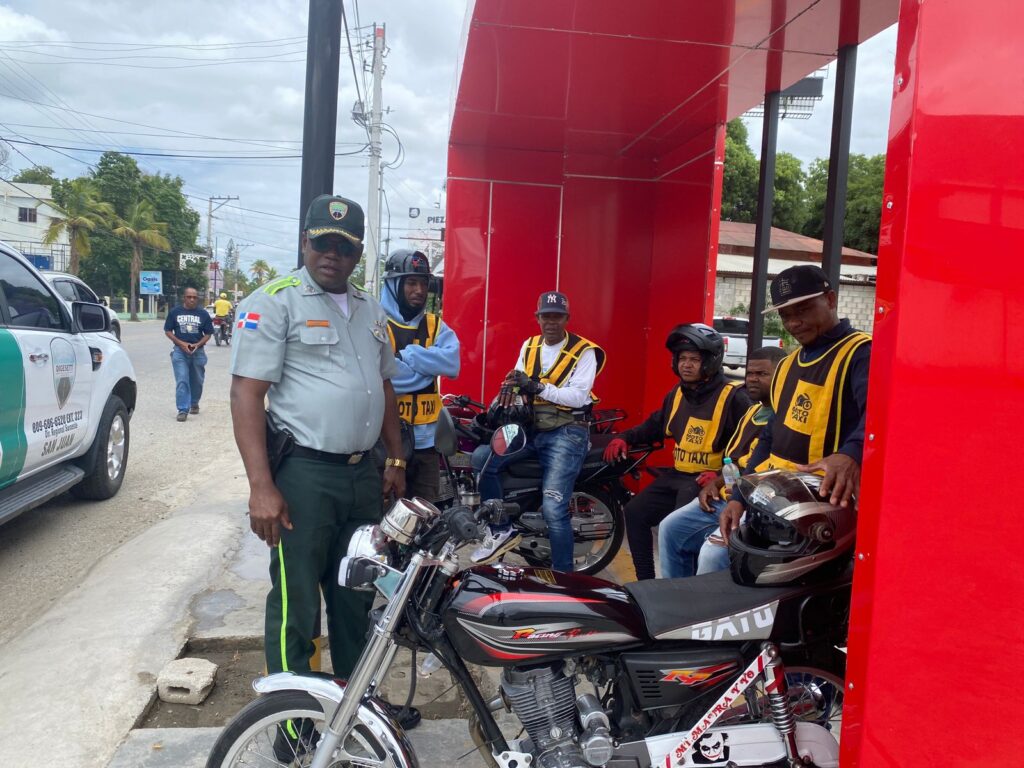 Agente de tráfico y mototaxistas en carretera.