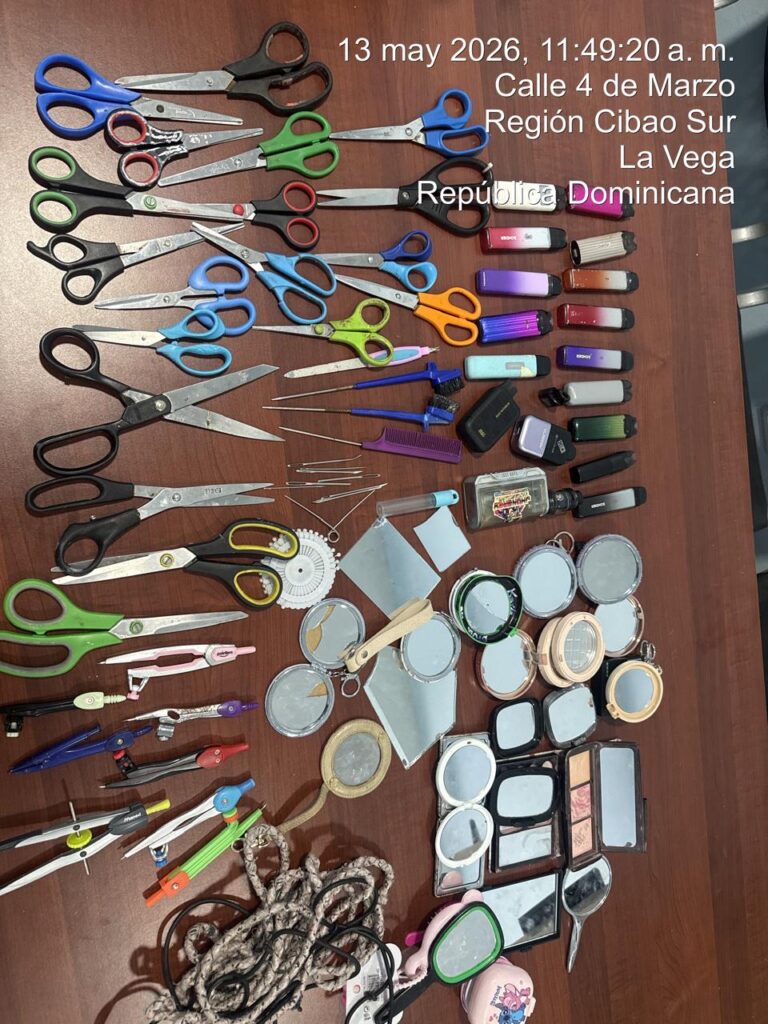 Variedad de tijeras, espejos y utensilios sobre mesa marrón.