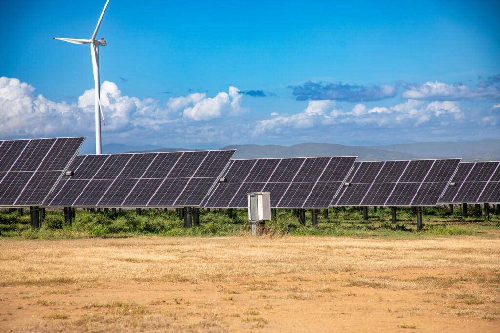 Paneles solares y molino de viento en el campo.