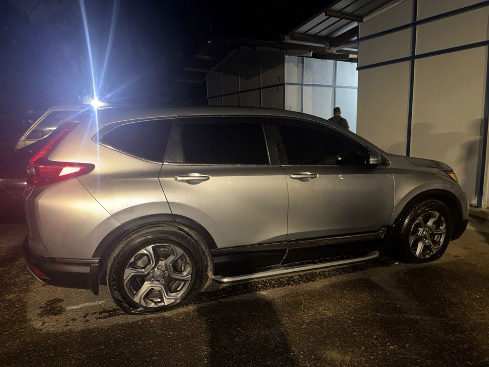 Coche gris estacionado en la noche.