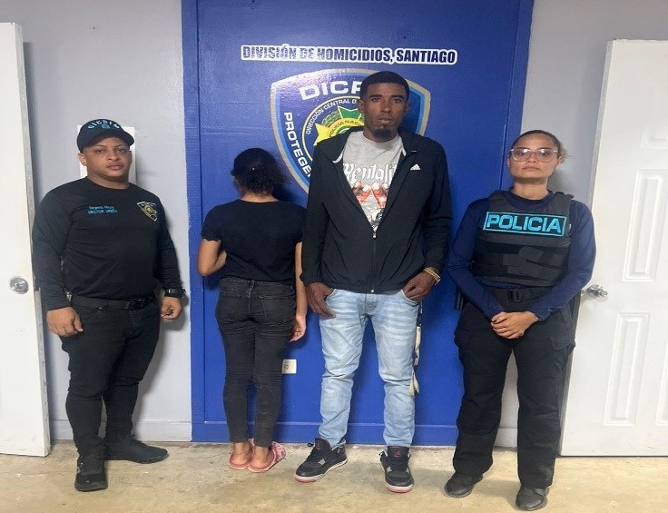 Cuatro personas frente a un cartel policial en Santiago.