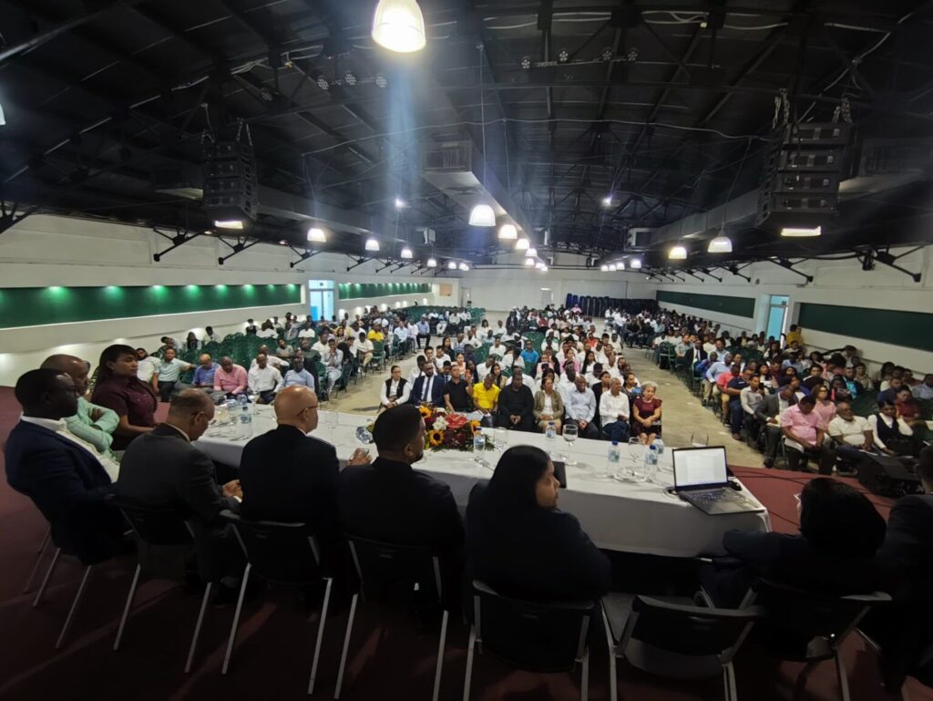 Conferencia con numerosos asistentes y mesa de ponentes.