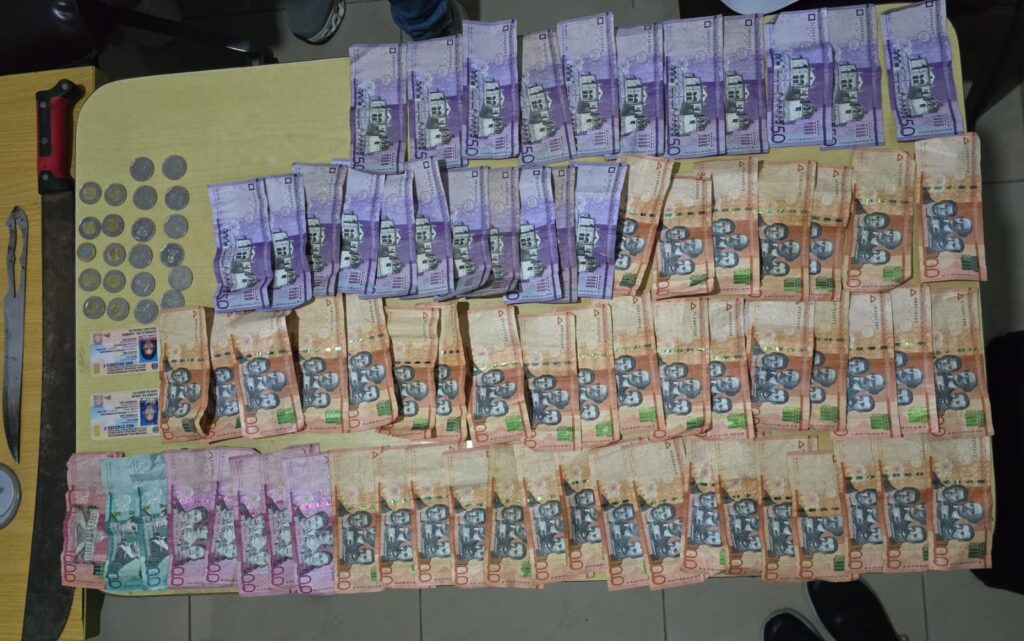 Billetes y monedas sobre una mesa con documentos.