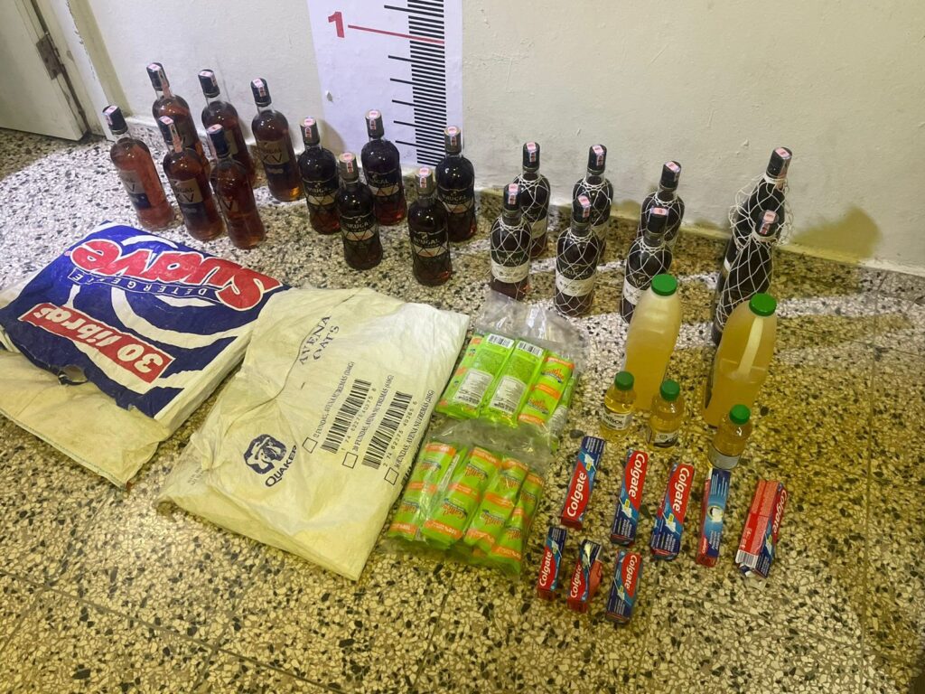 Botellas, bolsas de avena y productos variados en suelo.
