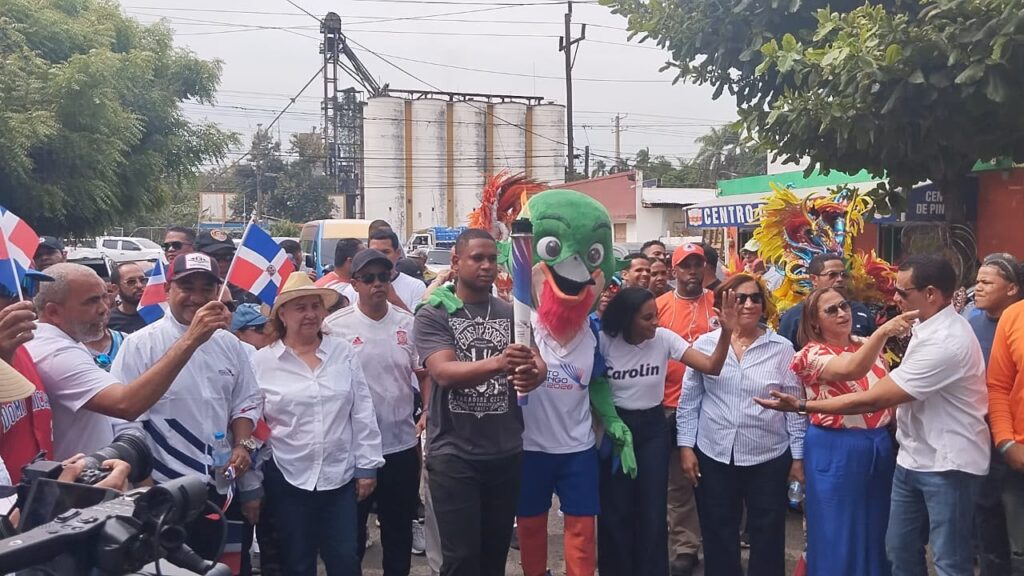 Grupo de personas con disfraces y banderas dominicanas.