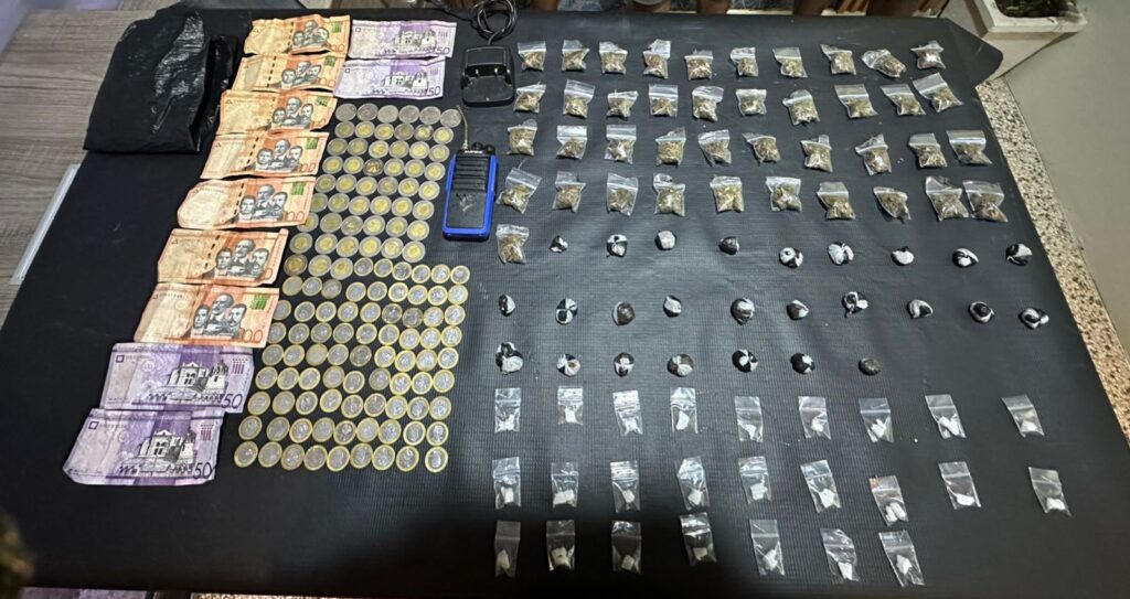 Dinero y bolsas en una mesa negra.