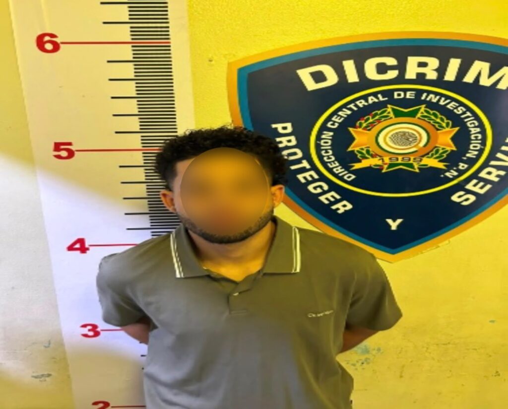 Persona frente a medidor de altura y escudo policial.
