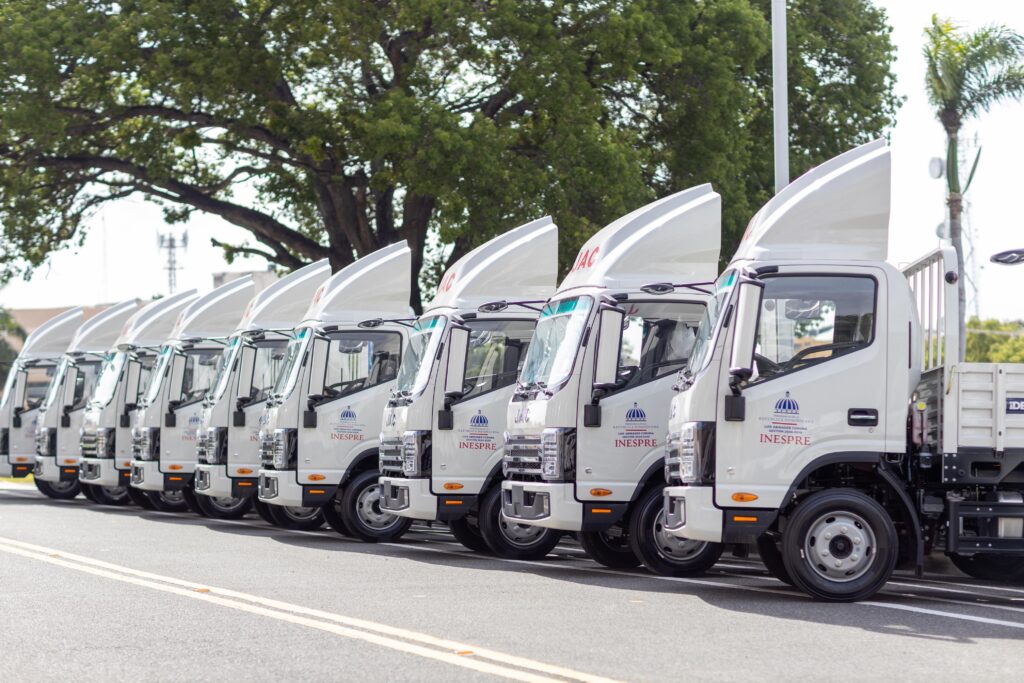 Fila de camiones blancos estacionados en la calle.