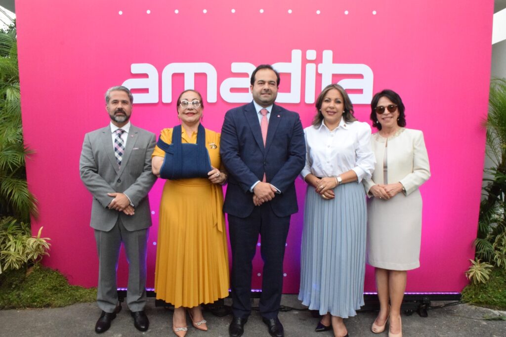 Cinco personas posan frente a un cartel de Amadita.