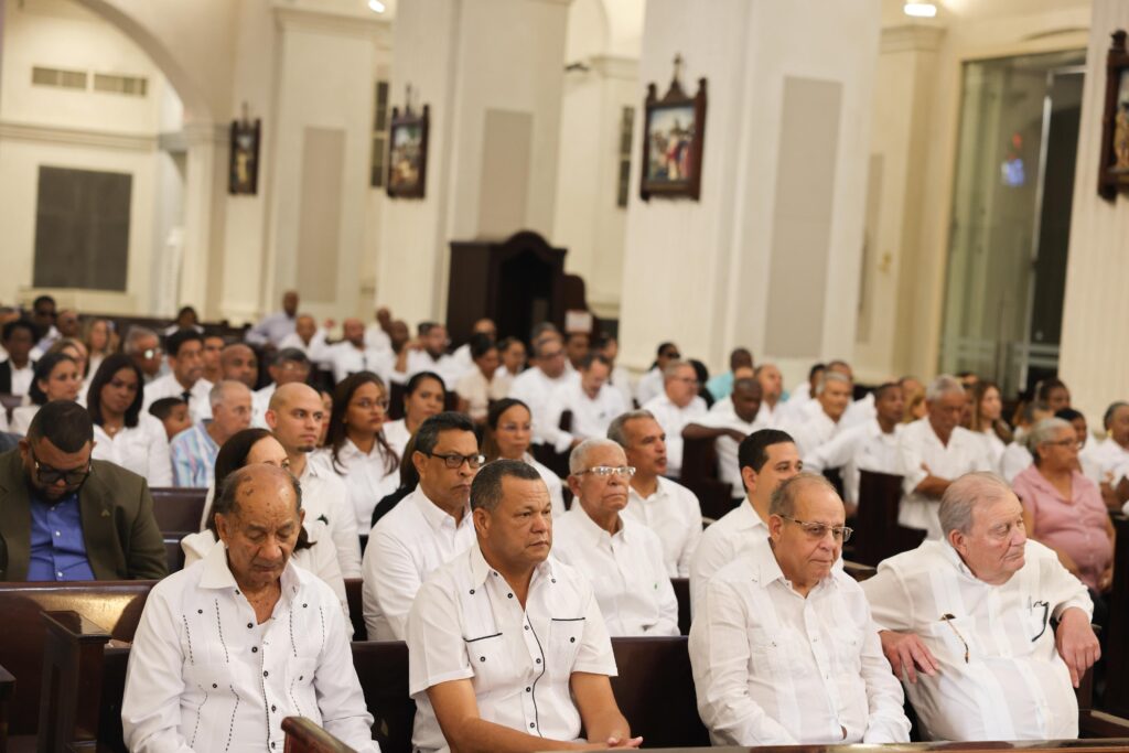 Personas reunidas en una iglesia, vestidas de blanco.