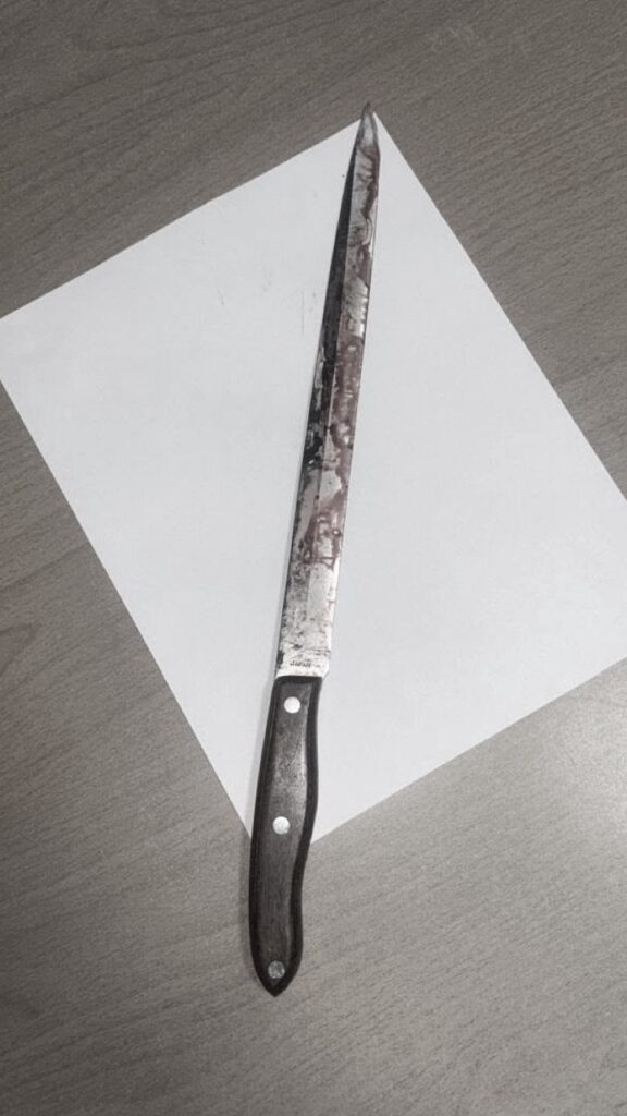 Cuchillo largo sobre papel blanco en mesa
