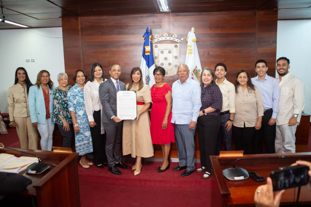 Grupo de personas en sala de reuniones oficial.