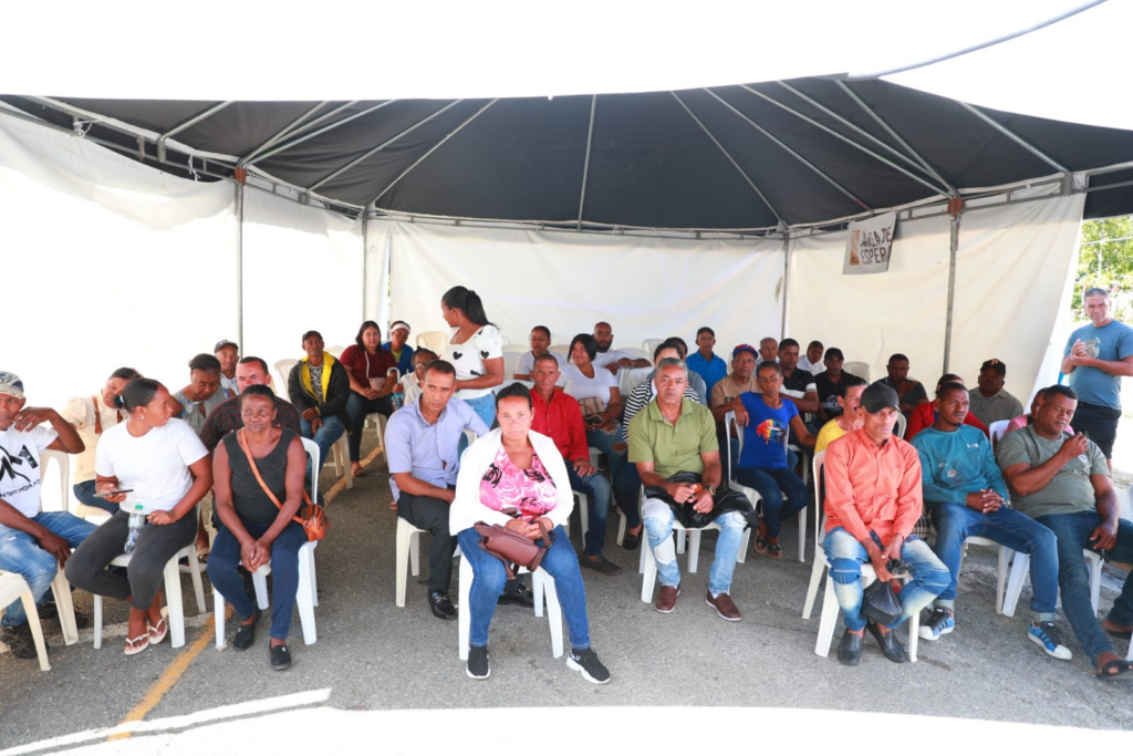 Personas sentadas bajo una carpa blanca